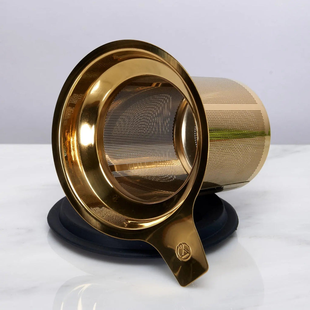 Gold tea infuser on a white background
