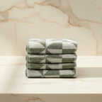 Stack of green checkered towels on a light background