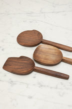 Selection of 3 assorted Une Vie Nomade walnut serving spoons on a white marble surface.