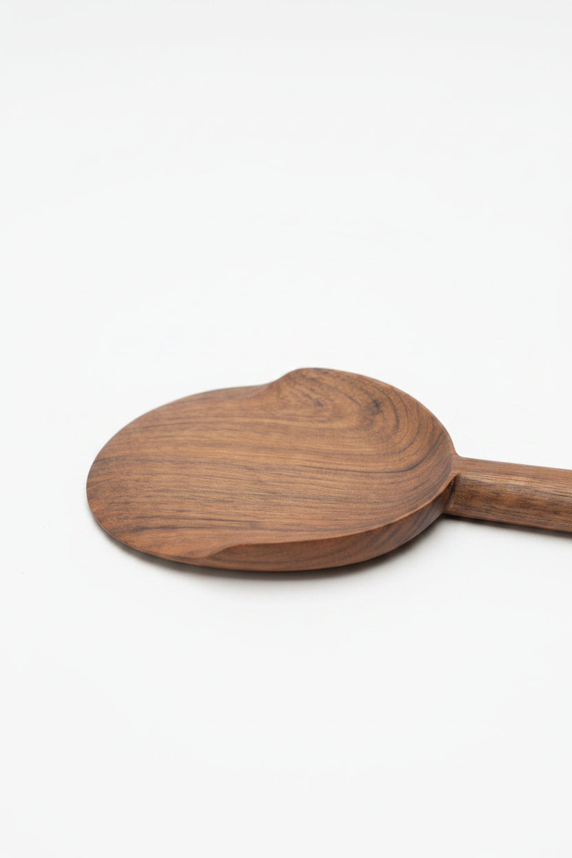 One Une Vie Nomade walnut serving spoon on a white surface.