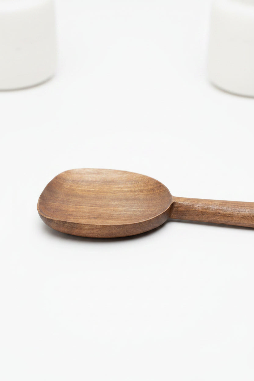 One Une Vie Nomade walnut serving spoon on a white surface.
