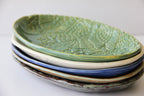 A stack of colored ceramic platters on a white surface.