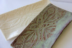 One cream rectangular platter and one green rectangular platter on a white surface.