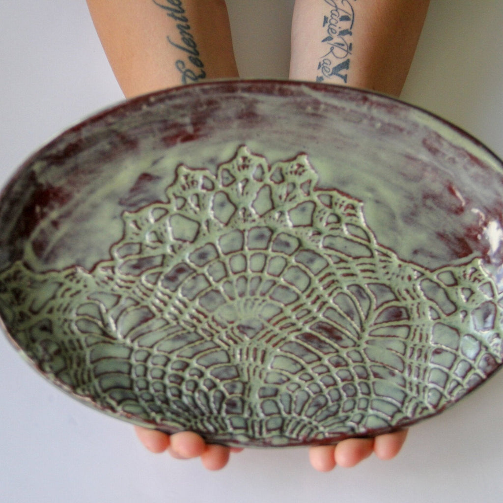 Green oval platter being held by a person.
