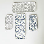 Set of four decorative mats with geometric, floral, and architectural patterns on white surface.