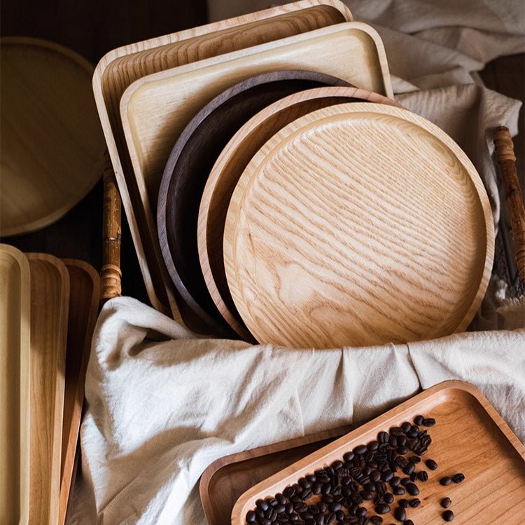 Set of wooden trays of various shapes and sizes on a light fabric background.