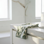 green and white geometric patterned towel on a bathroom vanity.