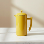A yellow Kuchenprofi French Press on a light background.