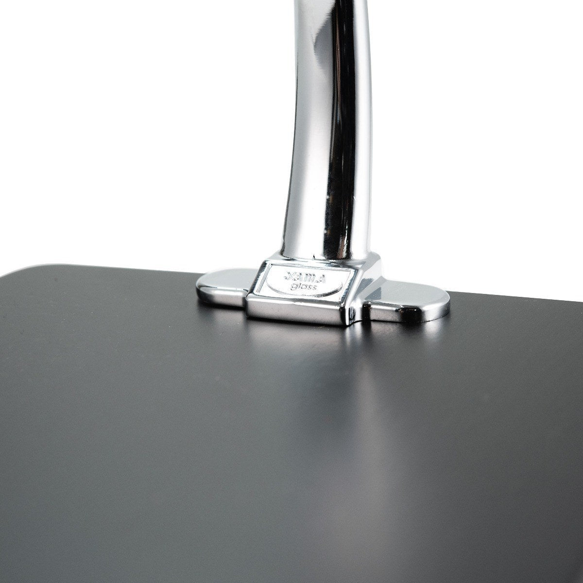 Close-up of a polished chrome metal stand for a Yama Glass Silverton Pour Over with a black stand against a white background.