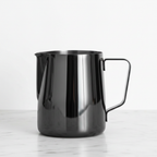 Barista Basics 20 oz. Milk Frothing Pitcher Black on a light surface.