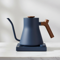 Fellow Stagg EKG Pro stovetop kettle in Stone Blue w/ Walnut with a light background.