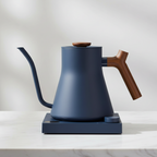 Fellow Stagg EKG Pro stovetop kettle in Stone Blue w/ Walnut with a light background.