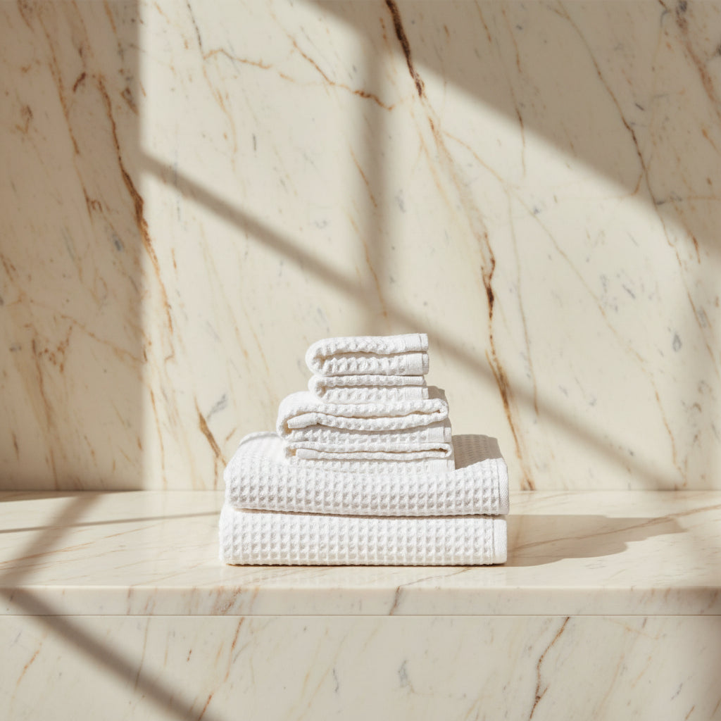 stack of white towels on a light surface.