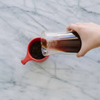 Gino Glass Coffee Server - 20oz/600ml with red coffee mug on a light background
