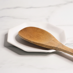Handmade White Porcelain Spoon Rest  with wooden spoon on a light surface.