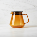 Hario Glass Coffee and Tea Server Amber on a light background.