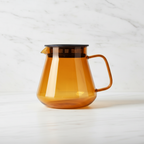 Hario Glass Coffee and Tea Server Amber on a light background.