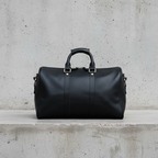 James Leather Duffle Bag in Black, front view, concrete background