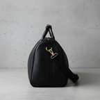 James Leather Duffle Bag in Black, side view, concrete background