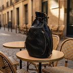 Remington Black Italian Leather Backpack on a Cafe Wooden Table with rattan chairs.