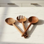 Set of three Une Vie Nomade long walnut spoons on a white background. 