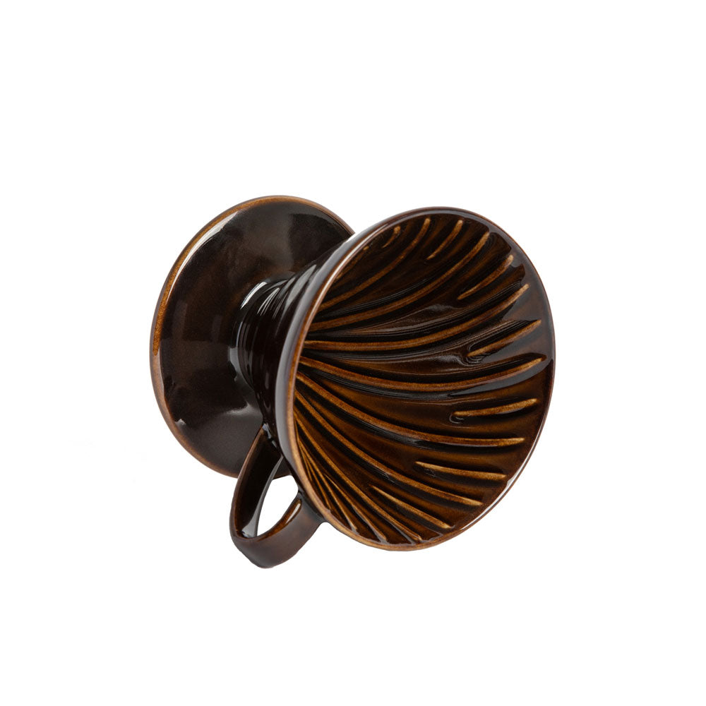 Side view of a brown colored coffee pour over dripper with a white background.