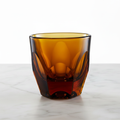 Vero Cappuccino Glass 6oz in amber — empty, handmade faceted glass on marble surface 