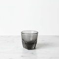 A smoke colored Vero espresso 3 oz. glass on a light background.