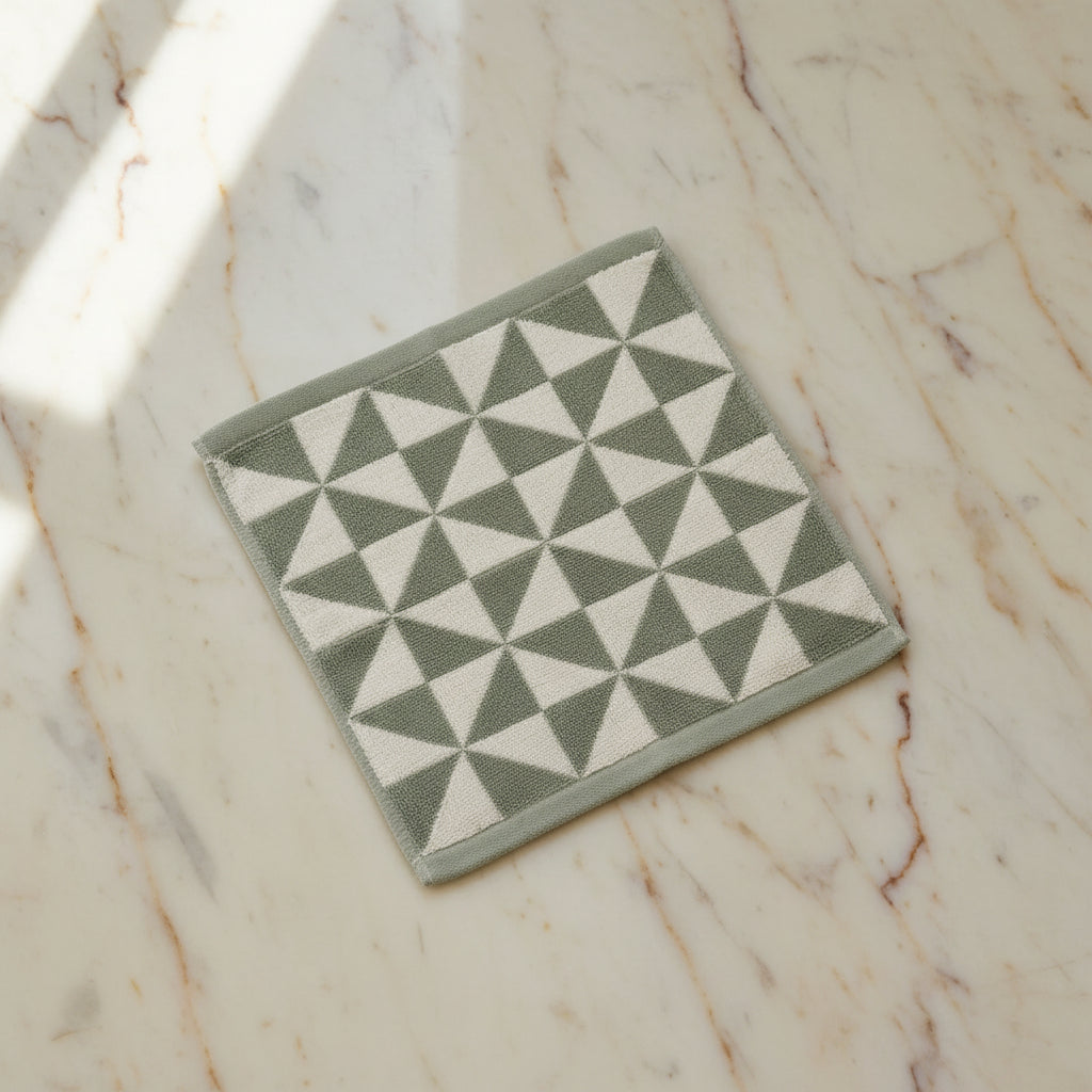 geometric patterned wash cloth on a light surface.